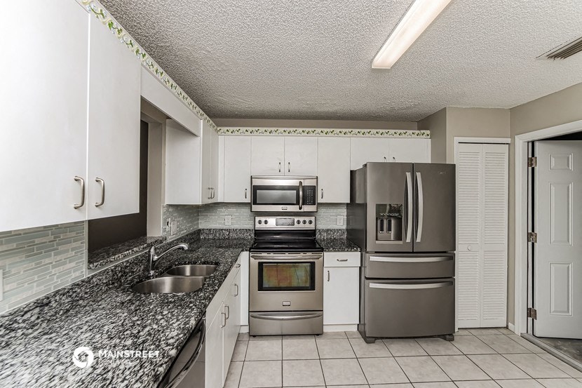 a kitchen with granite counter tops and stainless steel appliances
