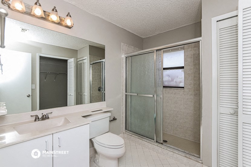 a bathroom with a shower and a sink and a toilet