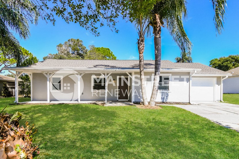 a house with a lawn and palm trees