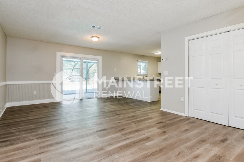 a renovated living room with white doors and a hard wood floor