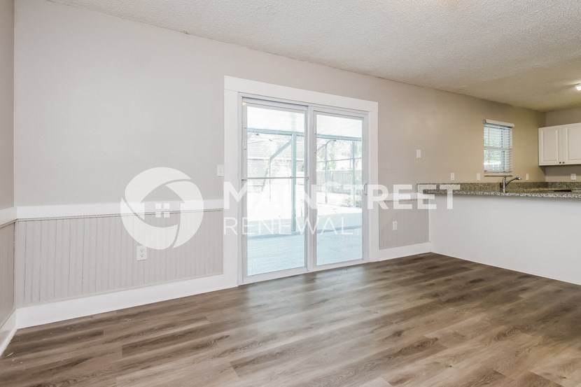 a studio apartment with a kitchen and a door to a balcony