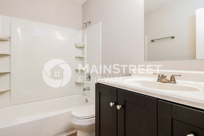 a white bathroom with a sink and a toilet