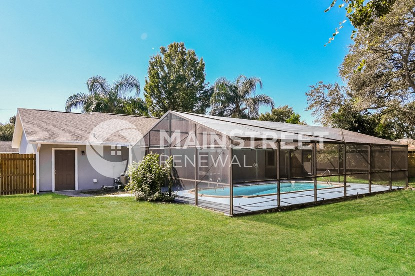 a backyard with a pool and a glass enclosure