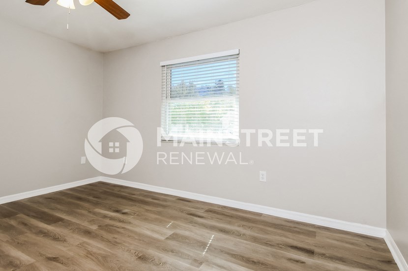 a room with a hardwood floor and a window