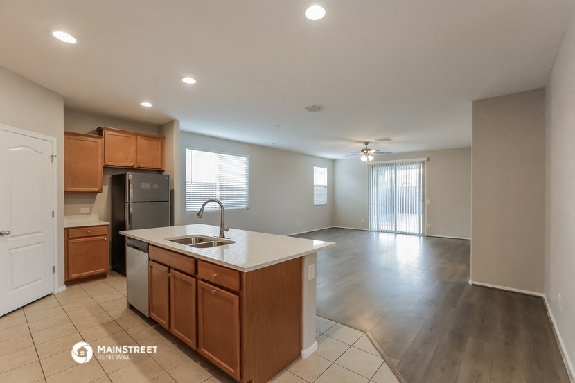 a kitchen with an island in the middle of it and a large empty living room