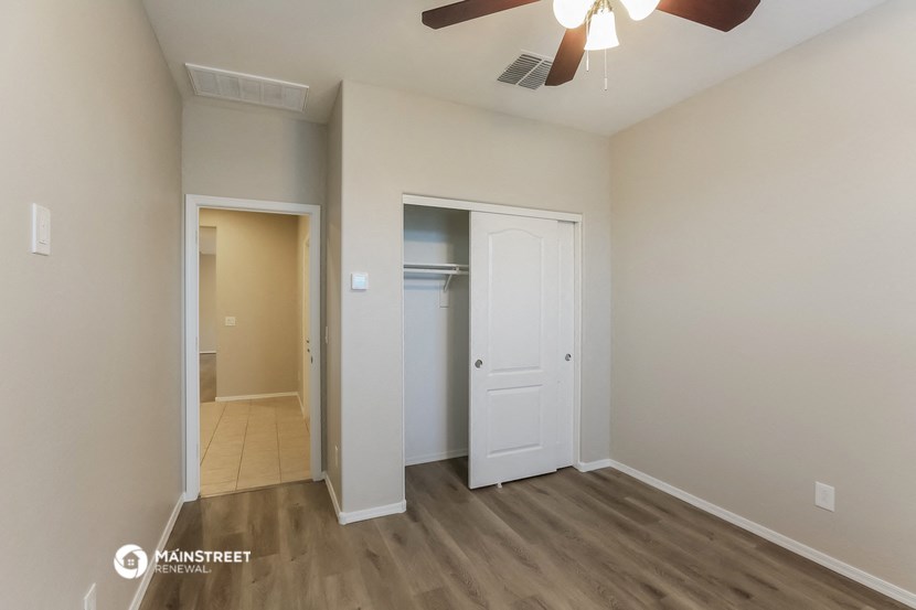 a bedroom with a closet and a ceiling fan