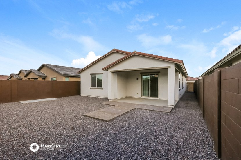 a home with a gravel driveway and a white house