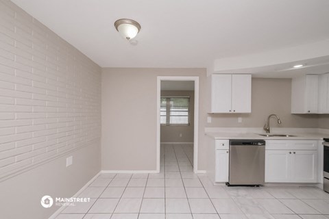 a kitchen with white cabinets and a counter top and a sink