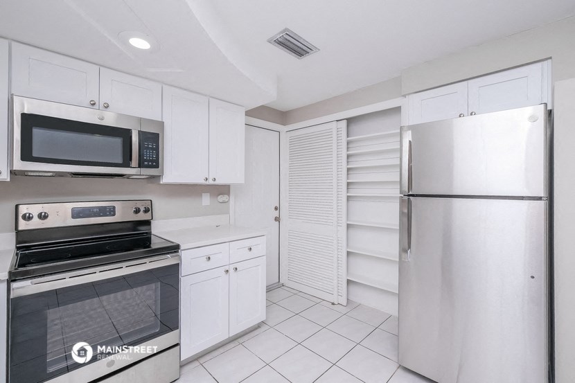 a kitchen with white cabinets and stainless steel appliances