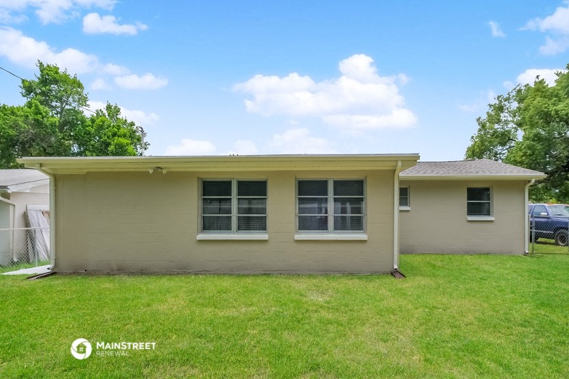 a small tan house with two windows on the side