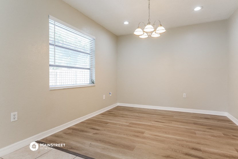 the spacious living room with hardwood flooring and a window