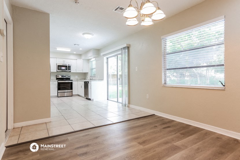 an empty living room and kitchen with a sliding glass door