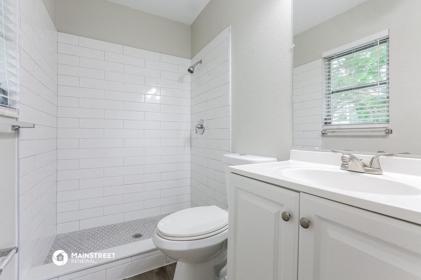 a white bathroom with a sink toilet and shower