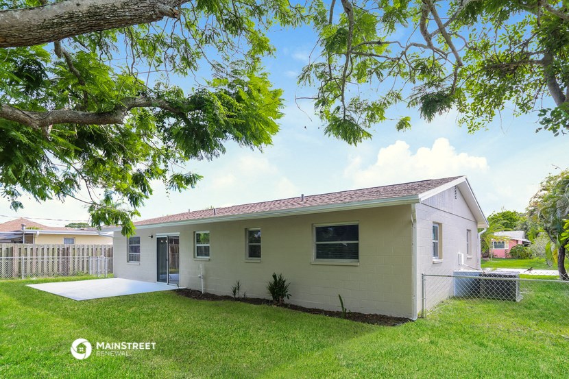 a small white house with a yard and a tree