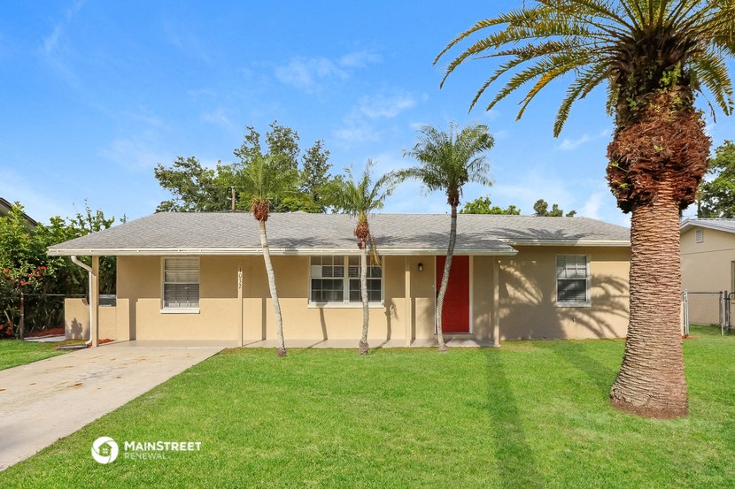 a yellow house with palm trees in front of it