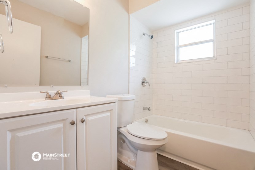 a bathroom with a sink toilet and tub and a mirror