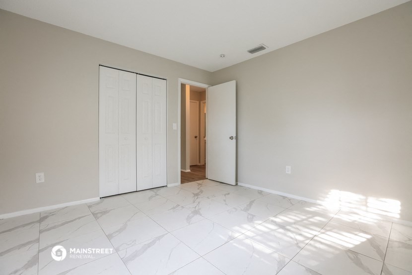 the living room of a new home with white marble flooring and a white door