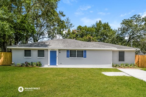 a small white house with a blue door and a lawn