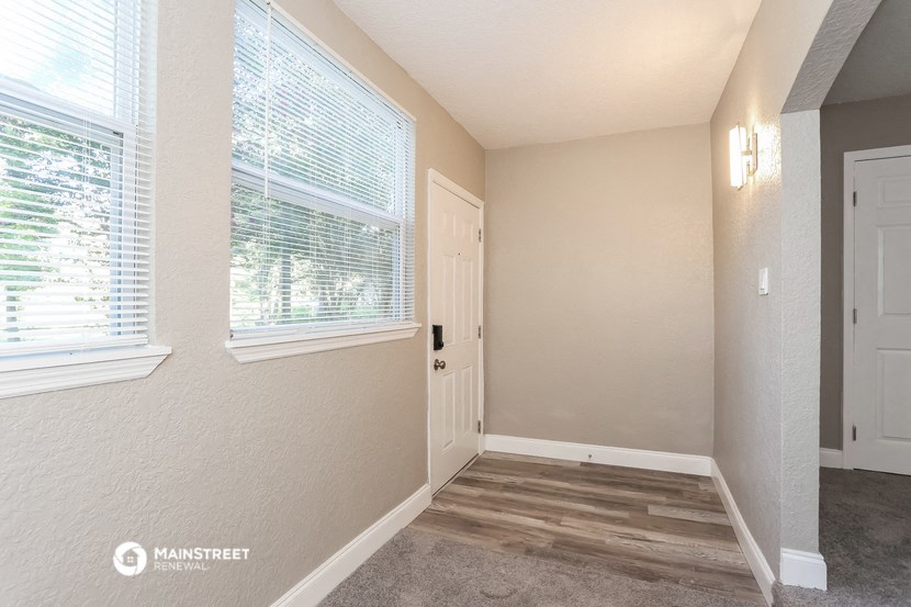 the interior of a home with a door and a window
