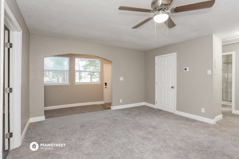 the living room of an empty house with a ceiling fan