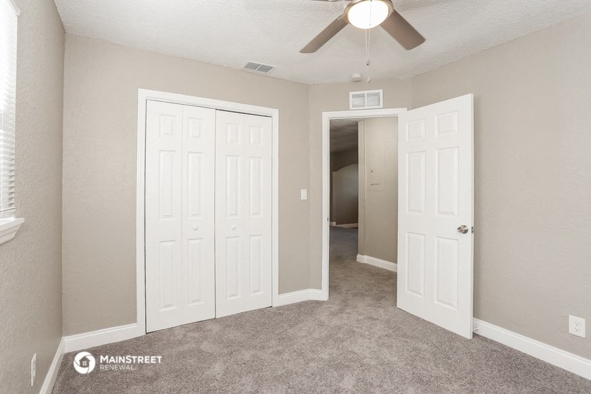 a bedroom with two closets and a ceiling fan