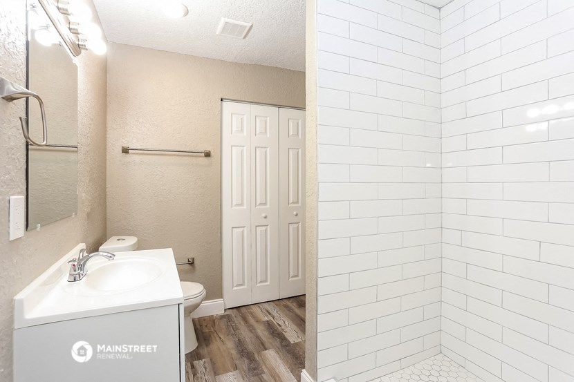 a bathroom with a shower and a sink and a mirror