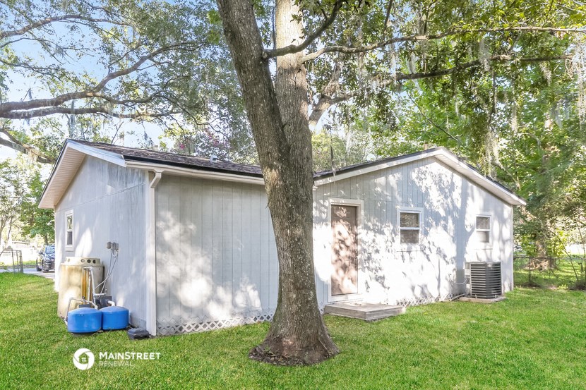 a small white house with a tree in front of it
