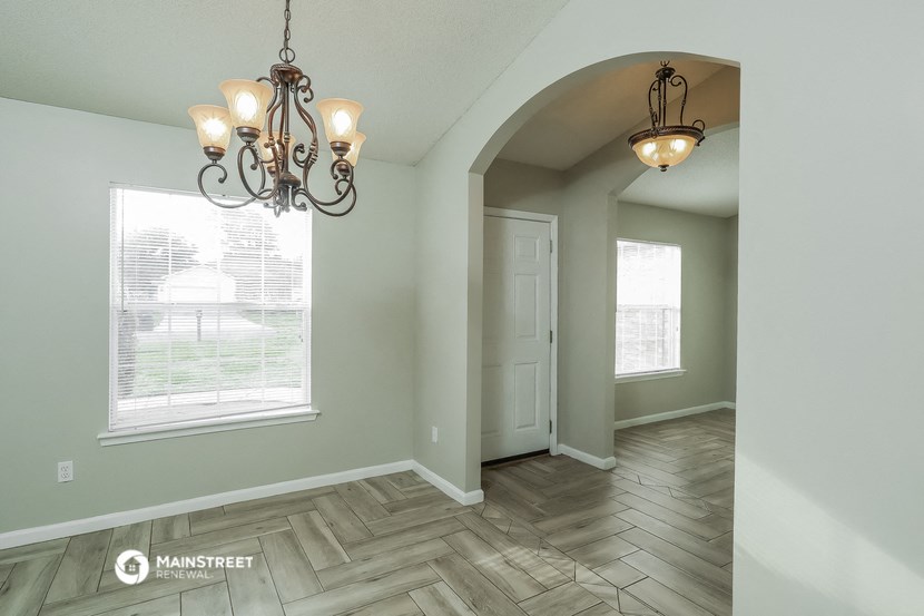 the entry of a home with a large window and a chandelier