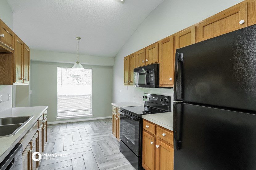 a kitchen with black appliances and wooden cabinets
