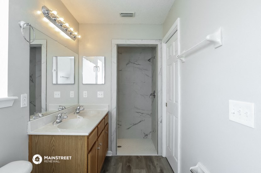 a bathroom with a shower and a sink and a mirror