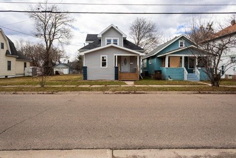 a blue and white house on the side of a street