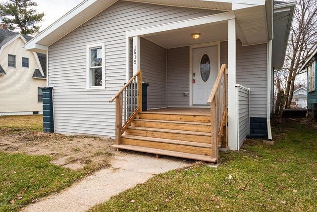 a white house with a wooden porch and stairs