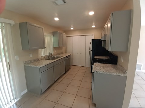 A kitchen with a sink and a refrigerator.