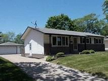 A house with a white garage door and a brown roof.