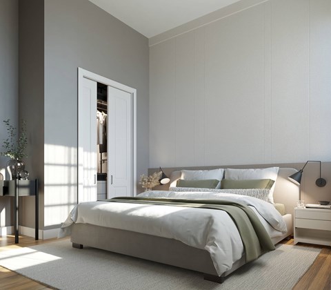 A modern bedroom with a large bed and a nightstand with a lamp.