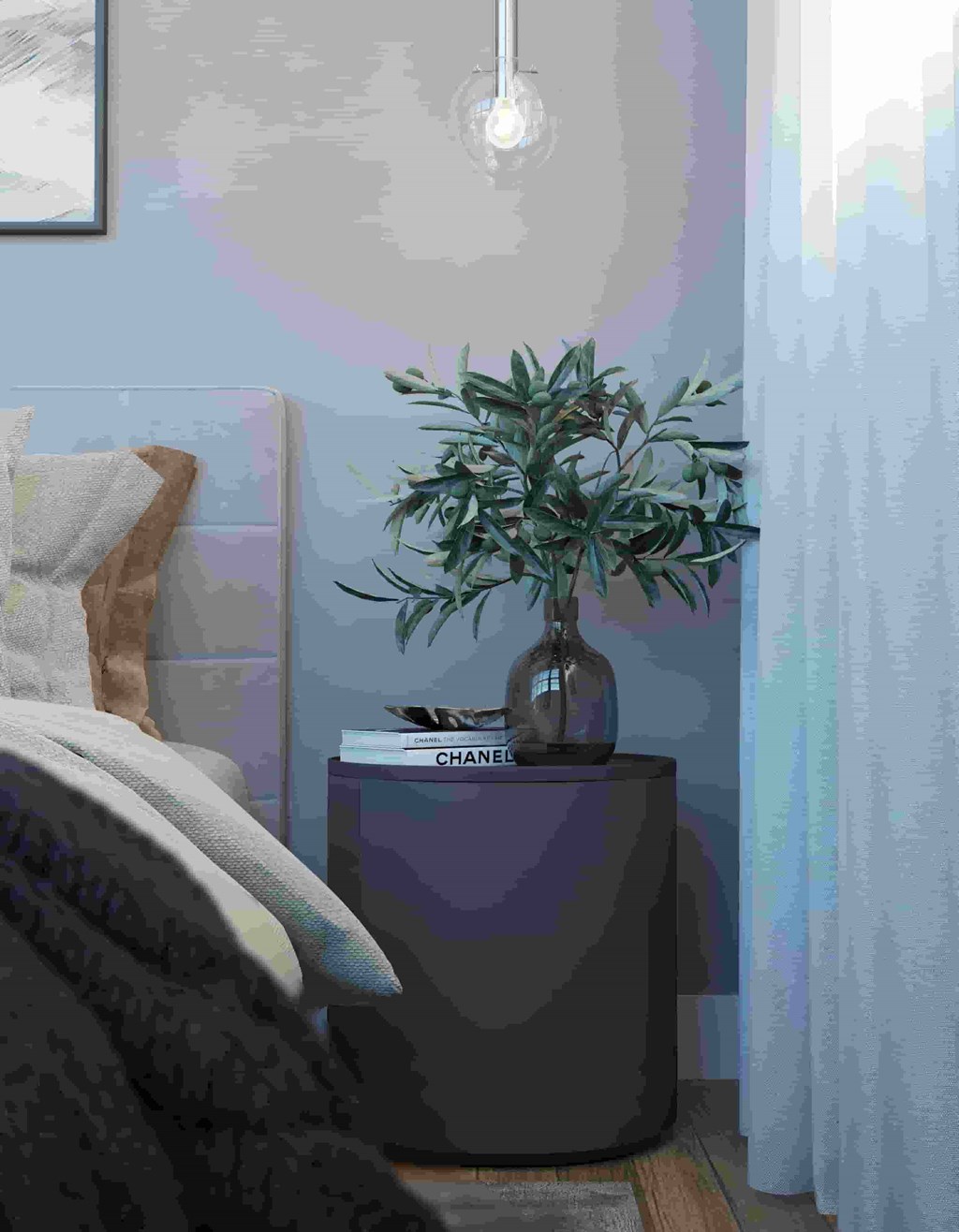 a vase with a plant on a table in a bedroom