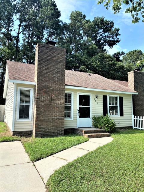 a small white house with a brick facade and a sidewalk