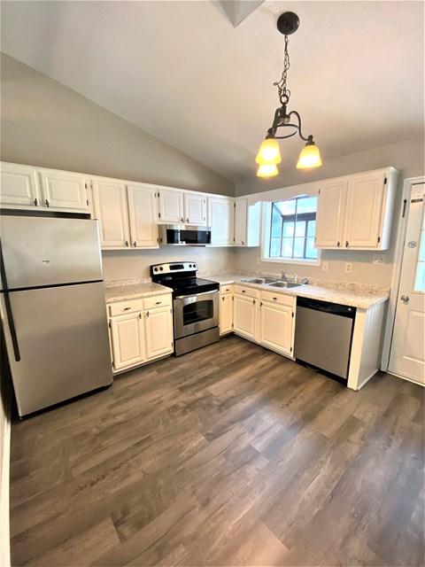 a kitchen with white cabinets and stainless steel appliances