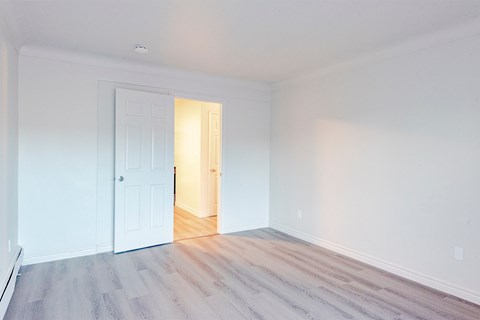 an empty room with white walls and a white door