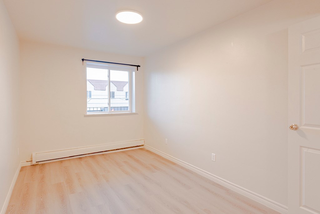 an empty room with white walls and a window