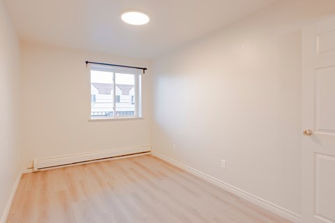 an empty room with white walls and a window