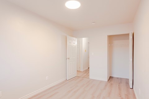 a renovated living room with white walls and wood flooring