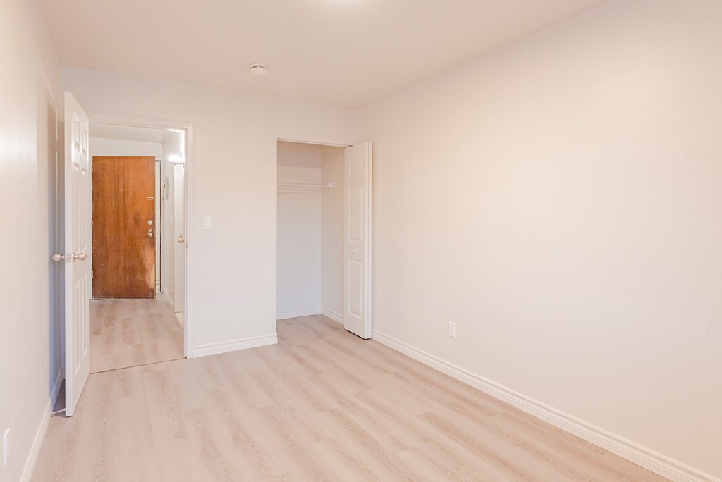 an empty room with white walls and a wooden floor