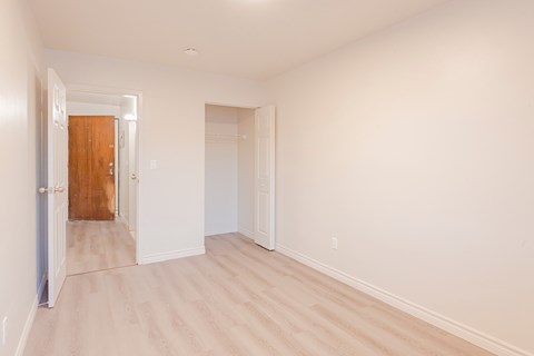 an empty room with white walls and a wooden floor
