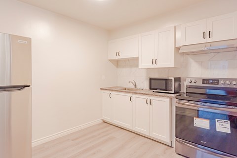 a kitchen with white cabinets and stainless steel appliances