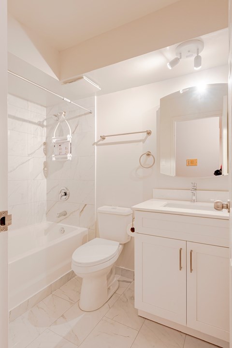 a white bathroom with a toilet sink and shower