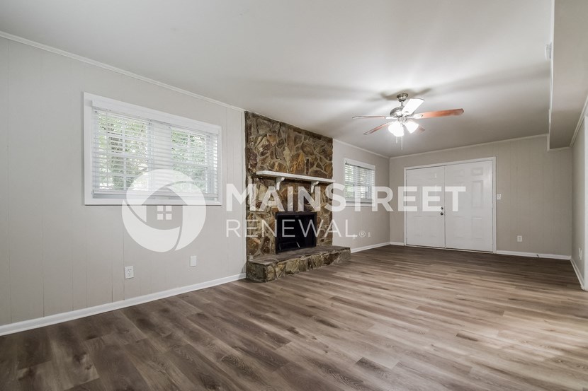 a renovated living room with wood floors and a fireplace
