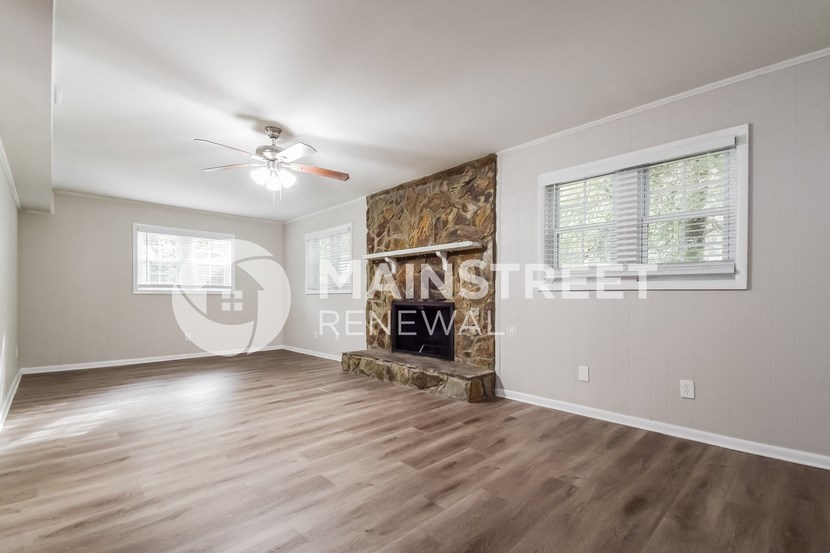 a living room with a fireplace and a ceiling fan