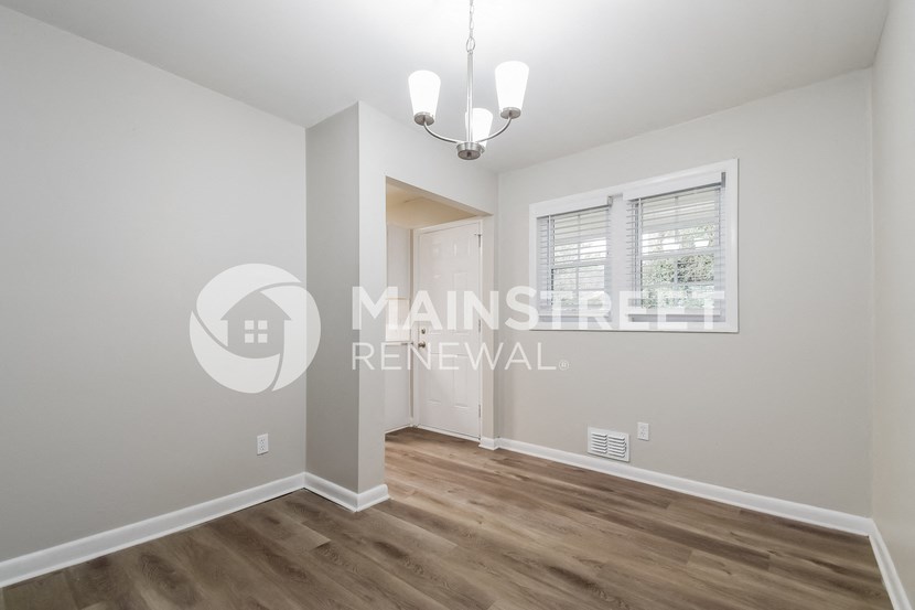 a renovated living room with a door to a hallway and a window