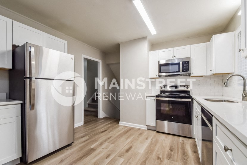 a renovated kitchen with white cabinets and stainless steel appliances